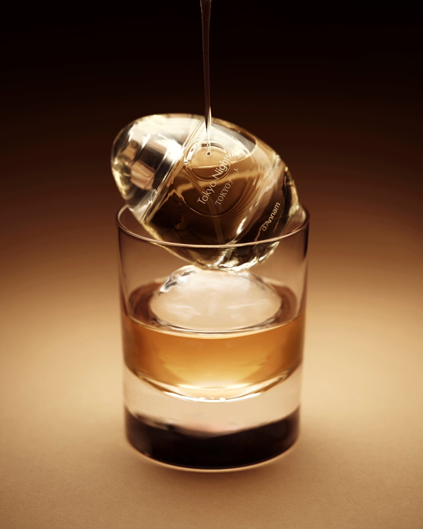 Tea bag being dripped into a glass of tea on a brown background