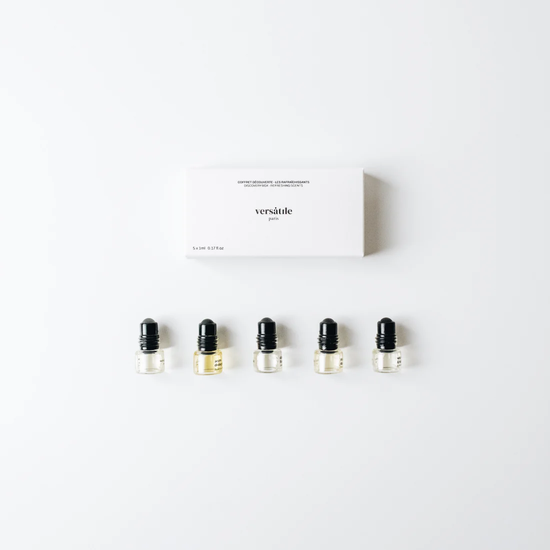 Set of small glass bottles with black caps on a white background, featuring the brand 'versatile'.