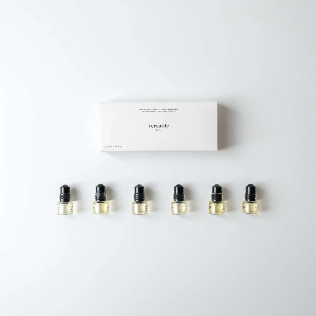 Set of six small black and gold bottles with a white box labeled 'versatile' on a light gray background