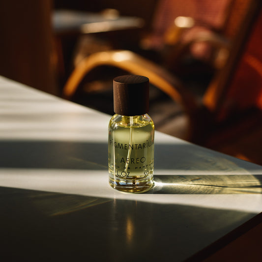 Small bottle of Aether on a reflective surface with a blurred background