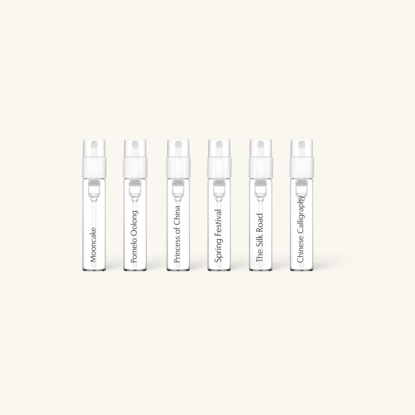 Set of five small perfume bottles with labels on a white background