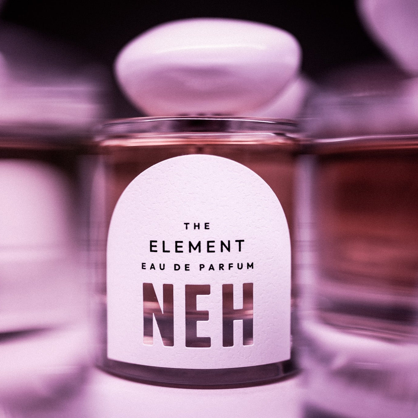 Perfume bottle labeled 'The Element Eau de Parfum NEH' with a blurred background
