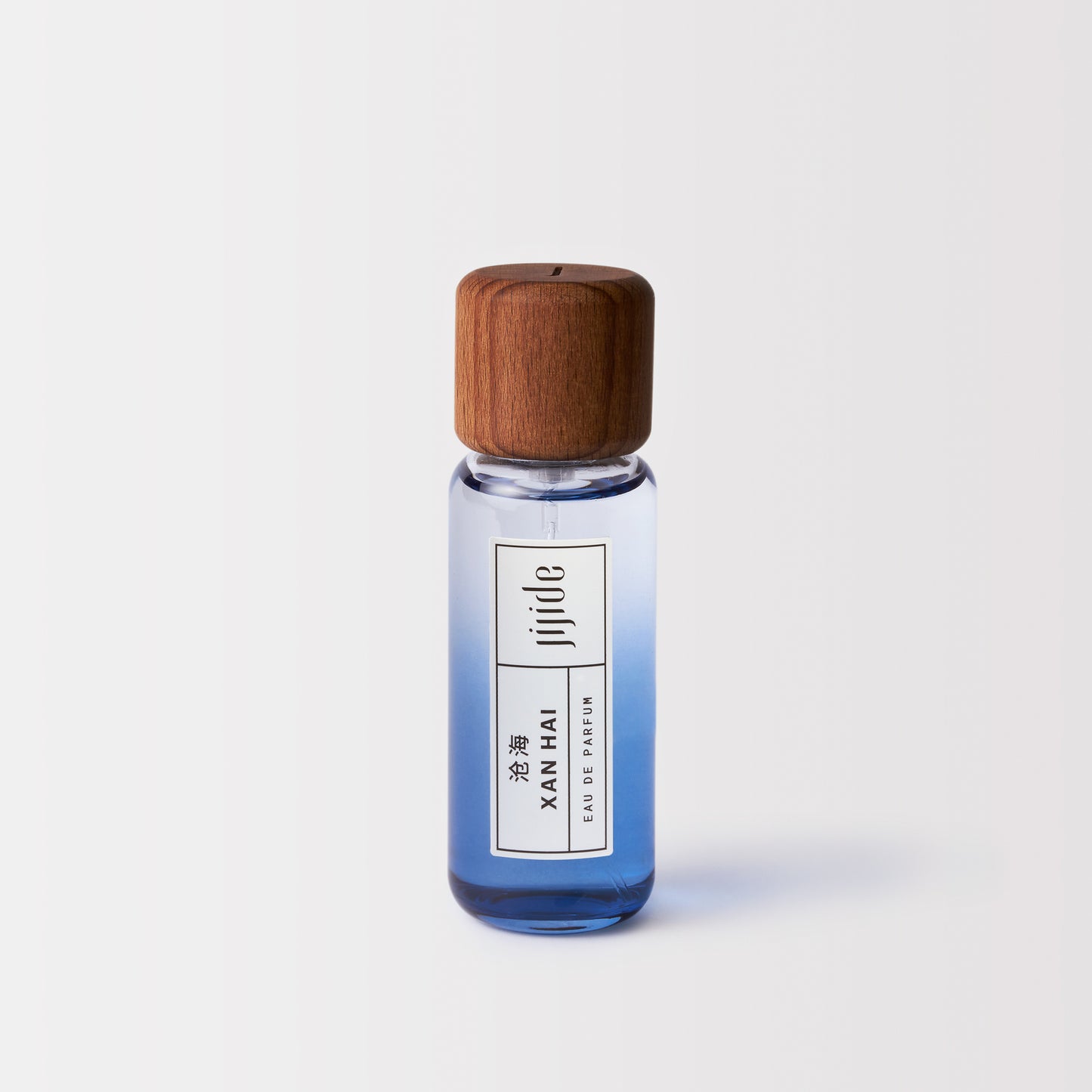 Small perfume bottle with wooden cap on a light gray background