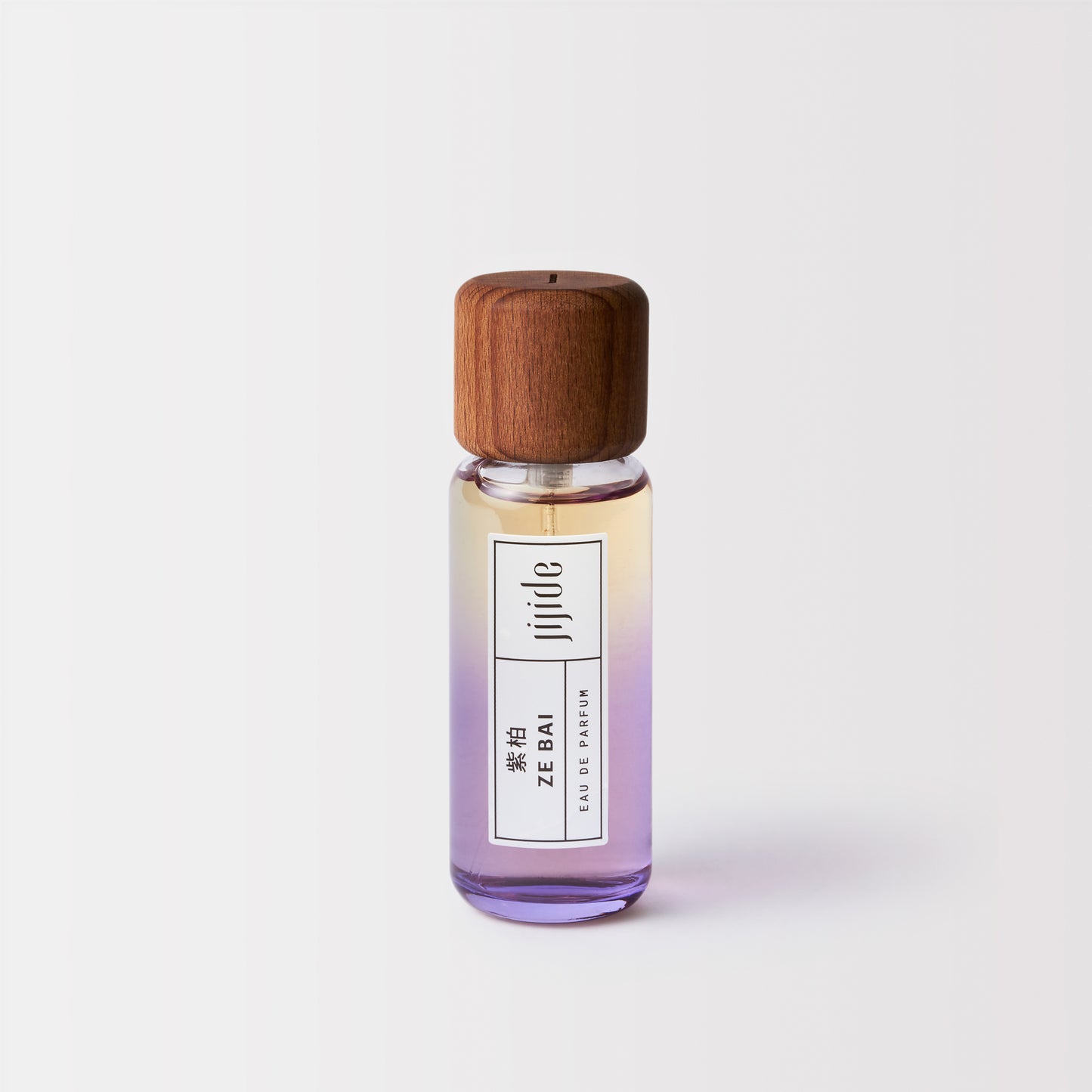 Small perfume bottle with wooden cap on a light gray background