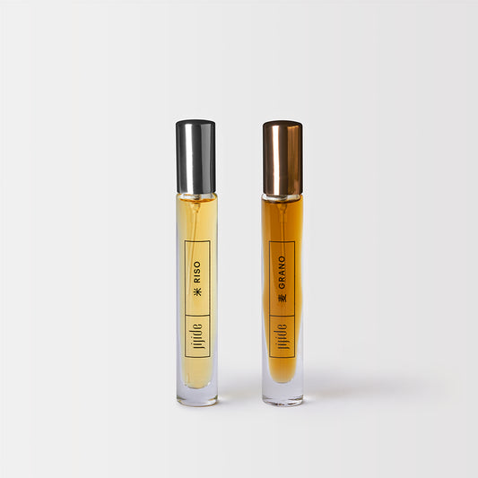 Two small glass bottles with metallic caps on a white background