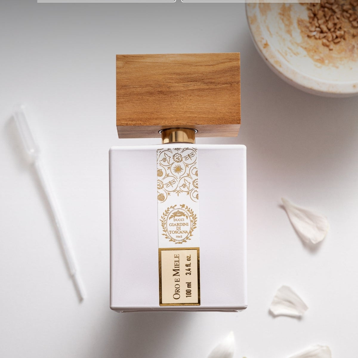 Perfume bottle with wooden cap on a white background, featuring 'Giardini di Toscana' branding.